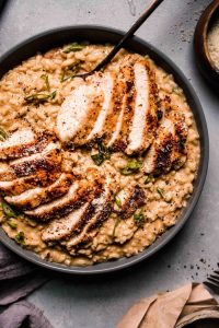 Creamy chicken and kale risotto topped with fresh asparagus and garlic, creating a deliciously vibrant dish.