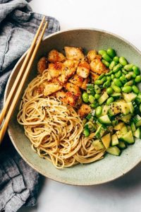 A delicious power-packed protein bowl with chicken, asparagus noodles, fresh cucumber, and creamy avocado for a nutritious feast.