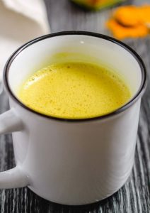 A cozy cup of turmeric tea, golden yellow in color, placed on a table, radiating warmth and comfort.