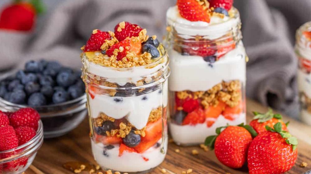 Nutty Berry Yogurt Delight: a bowl of raspberry yogurt overnight oats garnished with fresh berries and crunchy nuts.